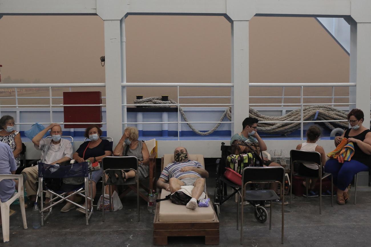 Les habitants et habitantes du village de Pefki sur l'île d'Eubée sont évacués par ferry, le 8 août 2021. [Keystone - Kostas Tsironis]