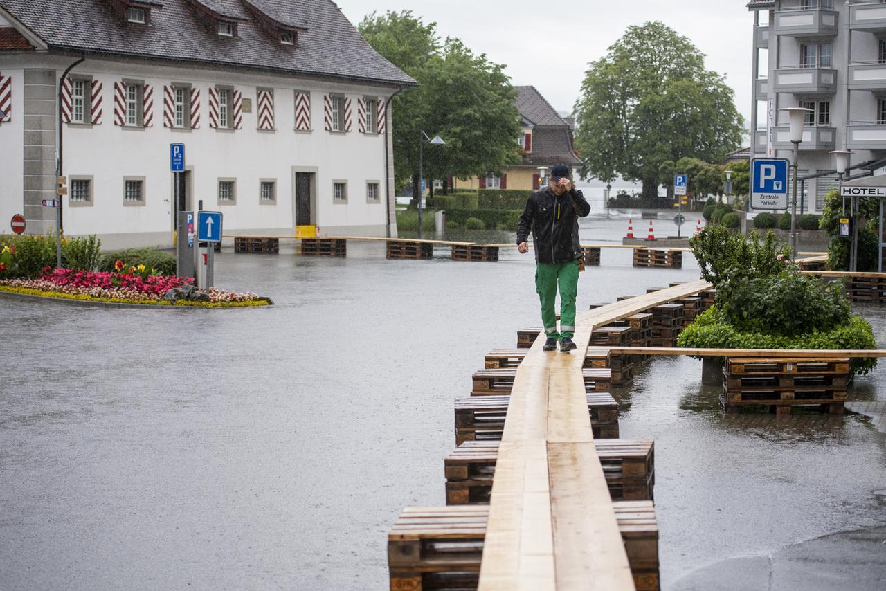 A Stansstad (NW), des passerelles ont été érigées pour pouvoir circuler alors que les eaux du lac des Quatre-Cantons ont pénétré dans les rues. [Keystone - Urs Flueeler]