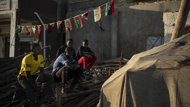 De jeunes migrants attendent d'être engagé à la journée à un carrefour des faubourgs de Tripoli, en Libye, le 27 février 2020. [AP/Keystone - Felipe Dana]