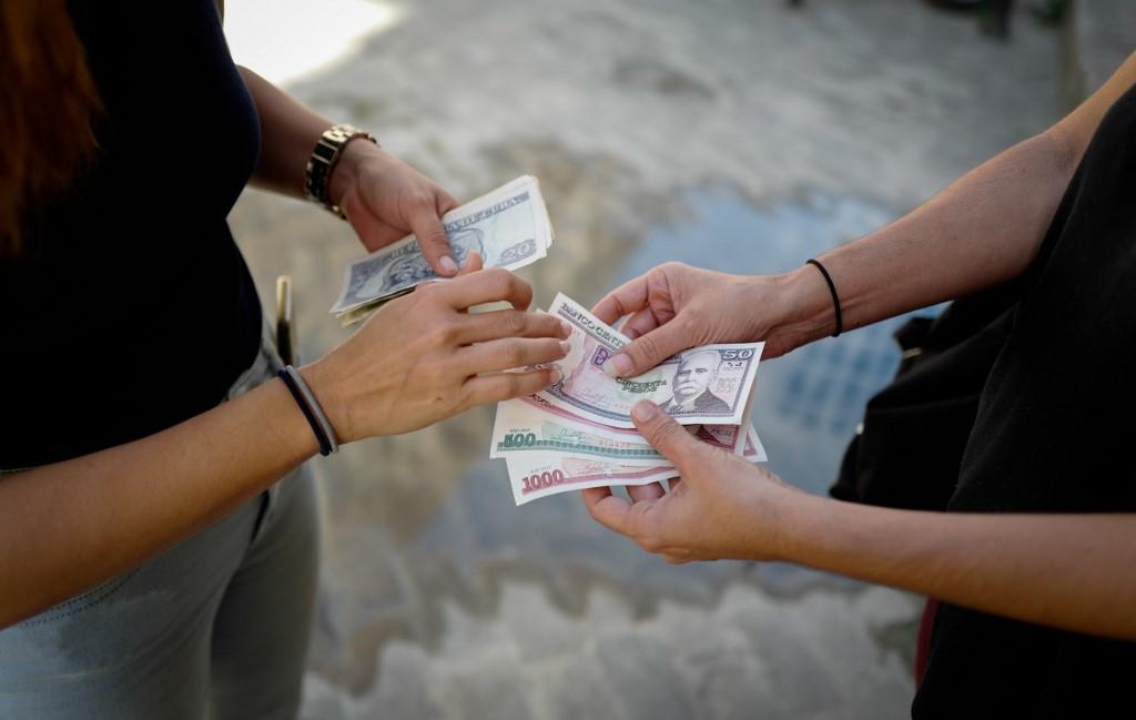 Deux personnes vérifient des billets de pesos cubains devant un bureau de change de La Havane. Cuba, le 15 décembre 2020. [AFP - Adalberto Roque]