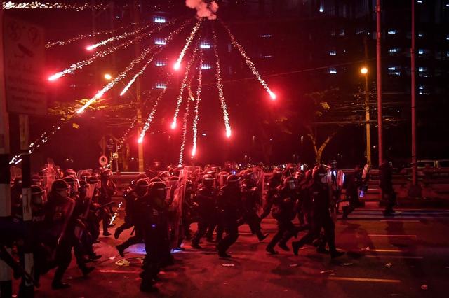 La police lance la charge contre les personnes manifestant pour la démission du Premier ministre thaïlandais, Prayut Chan-O-Cha. Bangkok, le 15 août 2021. [AFP - Lillian Suwanrumpha]