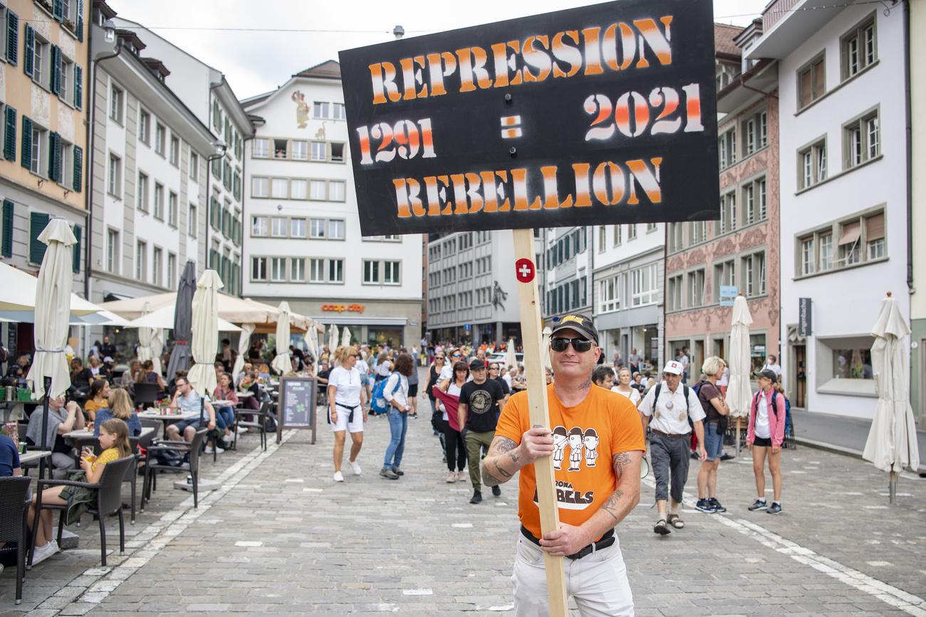 Un manifestant brandit une pancarte lors d'un rassemblement de l'Alliance "Urkantone" à Lucerne, le 31 juillet 2021. [KEYSTONE - Urs Flueeler]