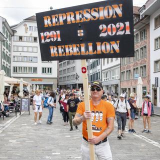 Un manifestant brandit une pancarte lors d'un rassemblement de l'Alliance "Urkantone" à Lucerne, le 31 juillet 2021. [KEYSTONE - Urs Flueeler]