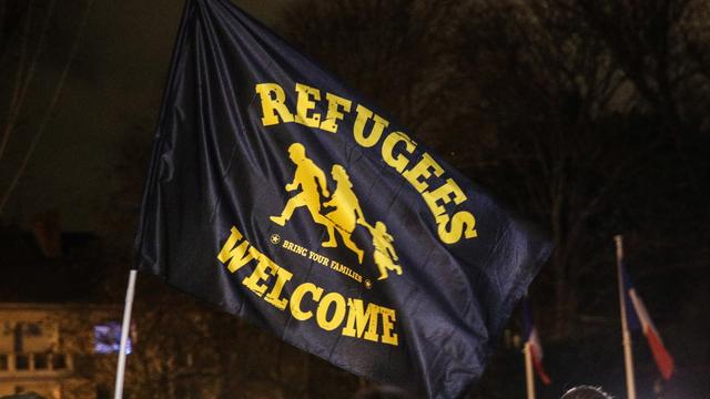 Des personnes manifestent pour rendre hommage aux 27 migrants morts dans le canal de la Manche, en tenant un drapeau avec la phrase "Refugees Welcome" au Parc de Richelieu à Calais, France, le 25 novembre 2021. [EPA/Keystone - Mohammed Badra]