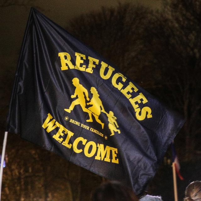 Des personnes manifestent pour rendre hommage aux 27 migrants morts dans le canal de la Manche, en tenant un drapeau avec la phrase "Refugees Welcome" au Parc de Richelieu à Calais, France, le 25 novembre 2021. [EPA/Keystone - Mohammed Badra]