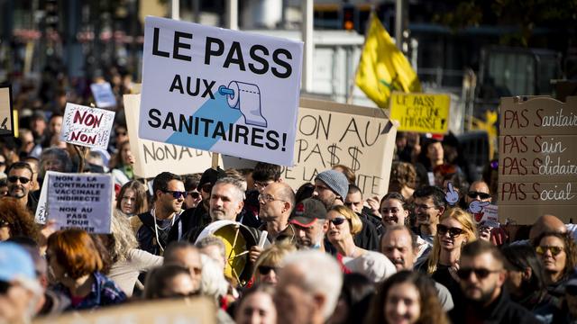 Des personnes manifestent lors d'un rassemblement "Non au pass sanitaire et a la restriction de nos libertes" le samedi 16 octobre 2021 a Lausanne. [KEYSTONE - Jean-Christophe Bott]