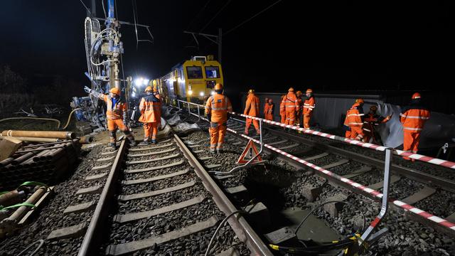 Des ouvriers préparent le ballast pour boucher le trou sur la ligne CFF entre Lausanne et Genève. [Keystone - Jean-Christophe Bott]