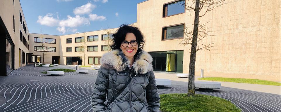 Christelle Luisier Brodard, debout dans la cour du collège de la Broye. [RTS - Karine Vasarino]