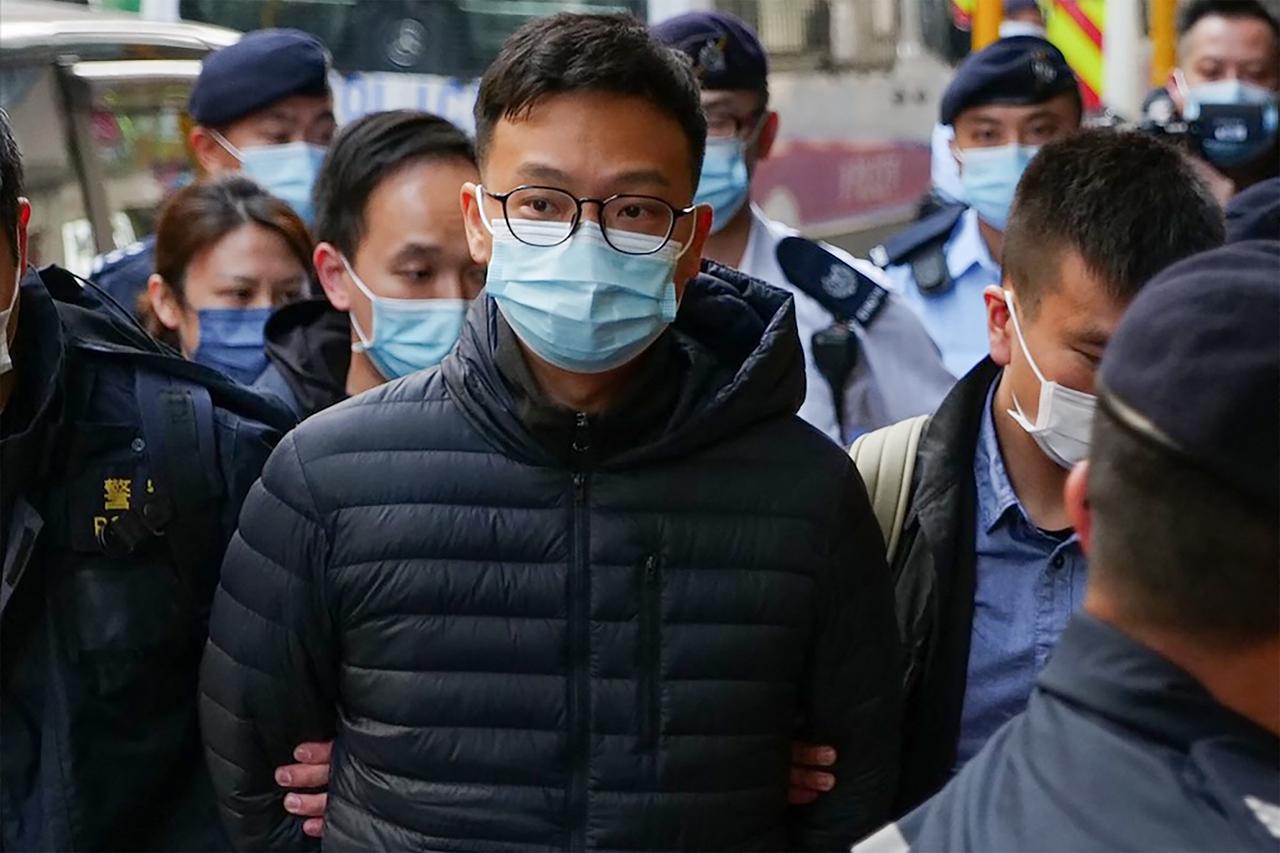 Patrick Lam, rédacteur en chef de Stand News, est emmené menotté dans les bureaux du média, le 29 décembre 2021. [AFP - Daniel Suen]