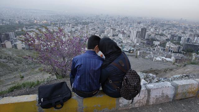 Un couple d'Iraniens partagent un moment au-dessus de la ville de Téhéran. [AP/Keystone - Vahid Salemi]