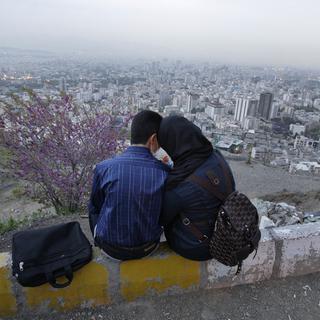 Un couple d'Iraniens partagent un moment au-dessus de la ville de Téhéran. [AP/Keystone - Vahid Salemi]