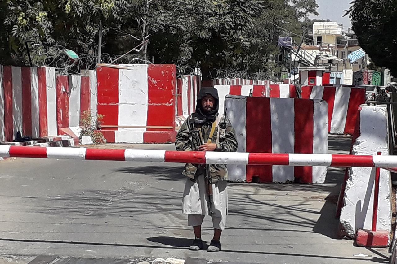 Un combattant taliban monte la garde devant le poste de police de Ghazni, le 12 août 2021. [AFP]