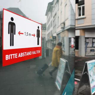 Un panneau rappelant les impératifs de distance sociale dans le ville de Bonn en Allemagne, le 8 janvier 2021. [Keystone - Oliver Berg]