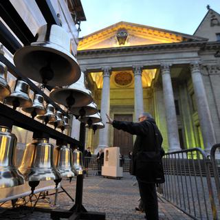 Des personnes observent les futures cloches du carillon de la Cathédrale Saint-Pierre, vendredi 18 mars 2011 à Genève. [KEYSTONE - Martial Trezzini]