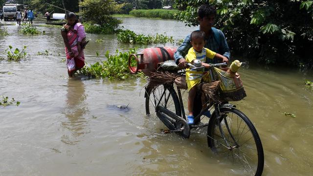 Des villageoises et des villageois s'extraient des eaux dans le district de Morigaon, dans l'Etat d'Assam. [NurPhoto via AFP - Anuwar Hazarika]