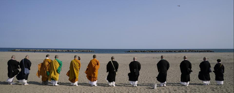 Des moines bouddhistes réconfortent les âmes des victimes du tremblement de terre et du tsunami dévastateurs du 11 mars 2011. Sendai, le 11 mars 2021, à 14h46, heure du séisme. [Keystone/epa - Kimimasa Mayama]