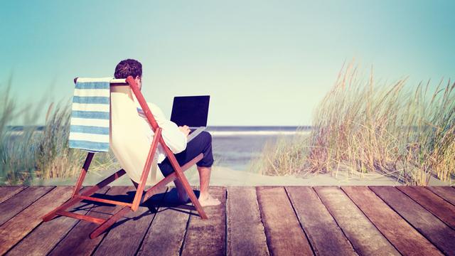 Un homme est en télétravail sur une plage. [Depositphotos - Rawpixel]