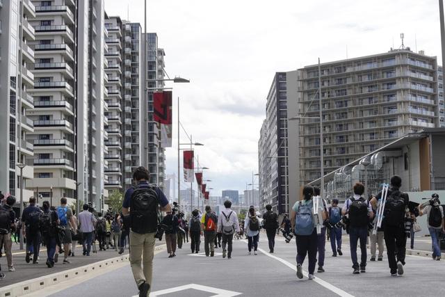 Des journalistes visitent le Village Olympique et Paralympique de Tokyo, le 20 juin 2021. [Keystone/epa - Kimimasa Mayama]