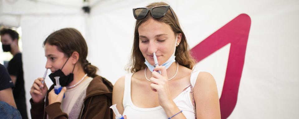 Des jeunes femmes pratiquent un auto-test du Covid-19, le 25 juin 2021 à Coire. [Keystone - Gian Ehrenzeller]