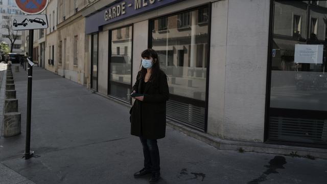 Une personne seule dans une rue de Paris le 24 mars 2021, alors que la capitale est soumise à des mesures sanitaires strictes. [Keystone - AP Photo/Francois Mori]