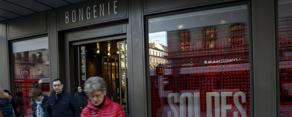 Des personnes passent devant les vitrines du magasin Bongenie ou le mot "soldes" est pose dans l'une des vitrines, lors du premier jour des soldes. [KEYSTONE - SALVATORE DI NOLFI]