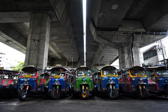 Sous une autoroute de Bangkok, des dizaines de tuk-tuks sont couverts d'une épaisse couche de poussière. [AFP - Lillian Suwanrumpha]