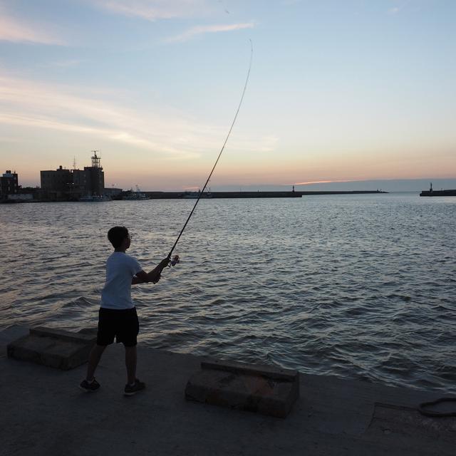 epa06933548 A boy catches fish at the Nanliao Port in Hsinchu City, western Taiwan, 07 August 2018. According to Hong Kong's South China Morning Post, China plans to extend its high-speed rail to Taiwan by building a rail tunnel under the Taiwan Strait. The 135-kilometre tunnel would link Pingtan in China's Fujian Province with Hsinchu on Taiwan's western coast. If all goes as planned by Beijing, high-speed trains would whizz through the world's longet undersea tunnel between Taiwan and China by 2030. According to news reports, while the Taiwan Strait tunnel is mainly for China's peaceful reunification with Taiwan, it is also part of President Xi Jinping's 'One Belt, One Road' strategy which promotes sea and rail links so that all countries can jointly achieve economic prosperity. Under that plan, China also hopes to extend its rail link from Russia to the US and Canada by building a tunnel under the Bering Strait; and to expend its high-seepd rail from Fujian to Taiwan, and then to the Phiilippines, other Southeast Asian nations, the Middle East and Europe. EPA/DAVID CHANG [EPA via Keystone - David Chang]