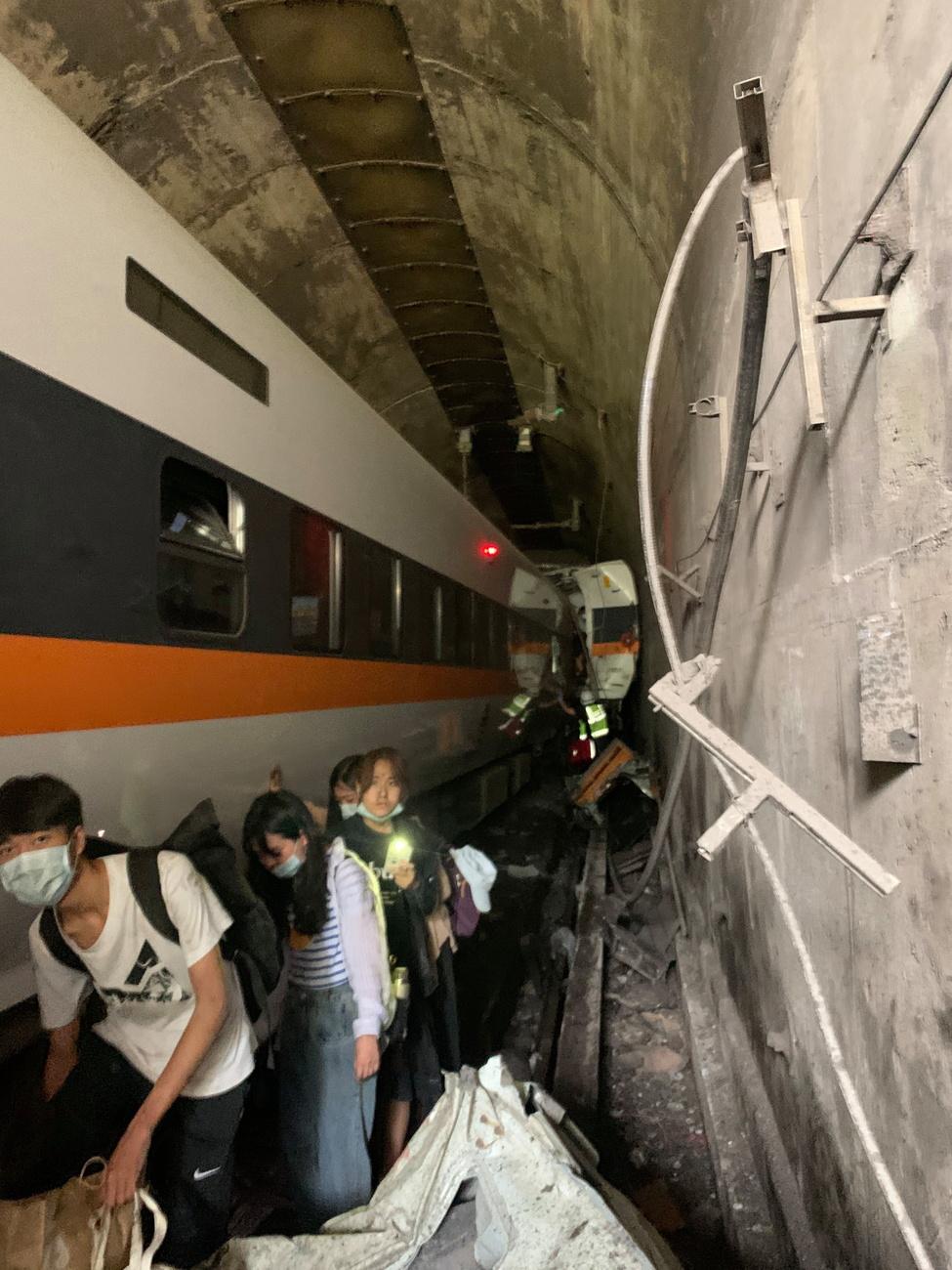 Des passagers évacuent du train accidenté dans le tunnel. [Keystone - EPA/Taiwan National Fire Agency]