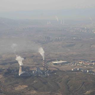 De la fumée et de la vapeur s'échappent des tours de la centrale thermique au charbon d'Urumqi en Chine. [AP Photo/Keystone - Mark Schiefelbein]