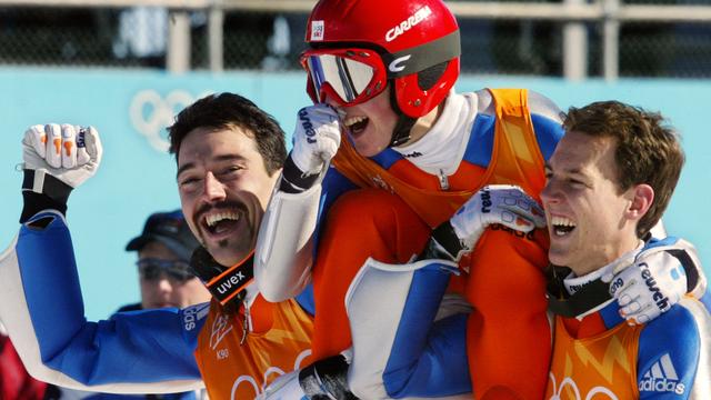 Une photo pour l'histoire du sport suisse. Sylvain Freiholz (à gauche) et Andreas Küttel portent Simon Ammann aux JO de Salt Lake City. [AFP - Cris Bouroncle]