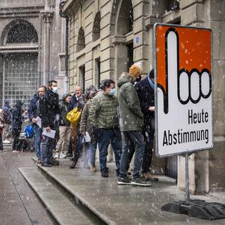 Les Suissesses et les Suisses ont été nombreux à se rendre aux urnes ce dimanche comme ici à Fribourg où une file d'attente s'est formée devant le bureau de vote. [KEYSTONE - JEAN-CHRISTOPHE BOTT]