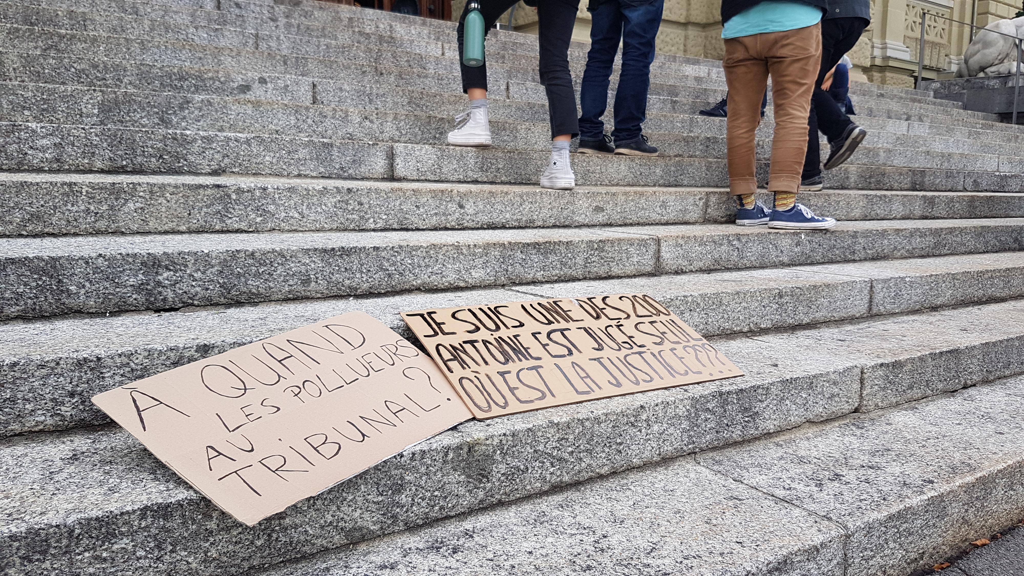 Des pancartes pour soutenir un activiste climatique devant la justice. [RTS - 15 Minutes]