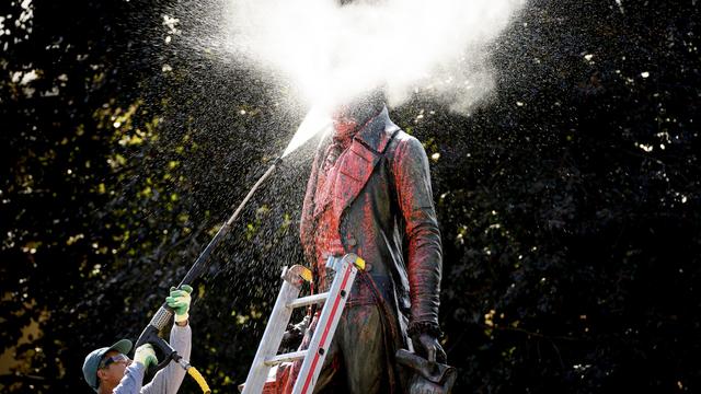 La statue de David de Pury éclaboussée de peinture rouge en plein nettoyage. [Keystone - Laurent Gillieron]