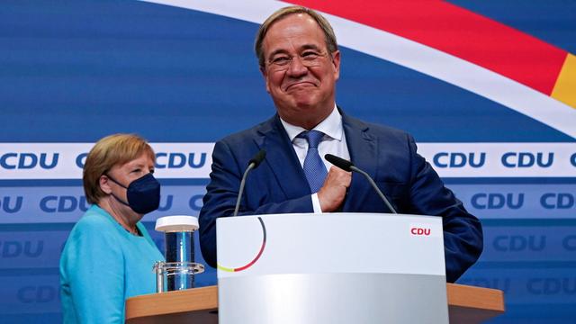 Armin Laschet, devant Angela Merkel, devant l'assemblée des militants de la CDU, après la proclamation des premiers sondages post-électoraux. [EPA/Keystone - CLEMENS BILAN]