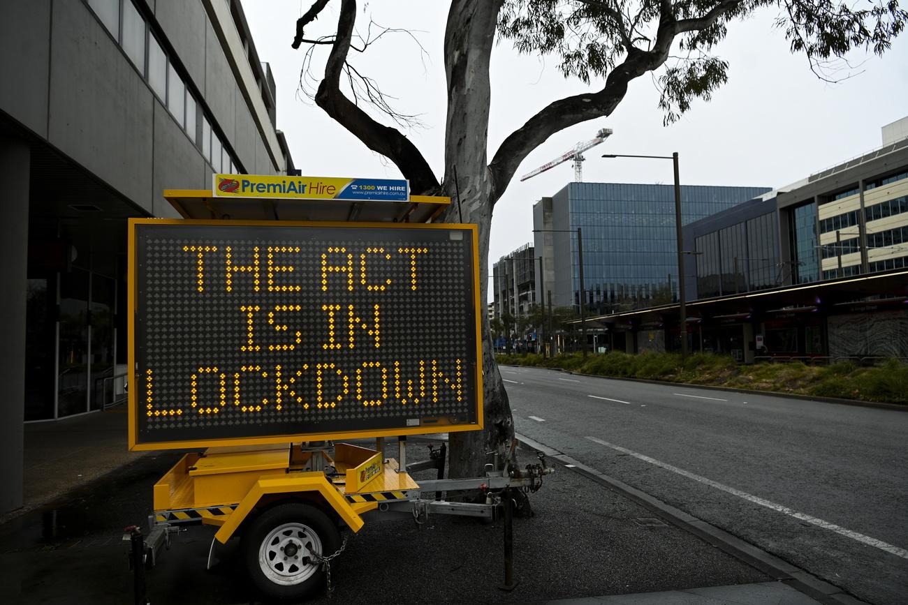 "Le territoire de la capitale australienne (ACT) est en confinement", dit ce panneau dans une rue de Canberra. Australie, le 24 août 2021. [Keystone/epa - Lukas Coch]