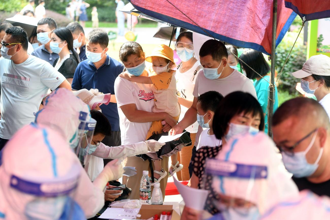 Des résidents de Wuhan font la queue pour se faire tester, le 3 août 2021. [KEYSTONE - Shepherd Zhou / EPA]