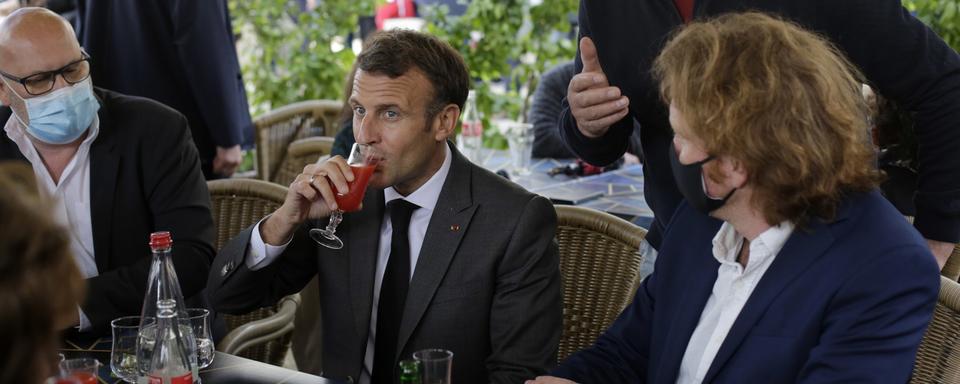 Le président français Emmanuel Macron partage un verre avec des commerçant.e.s à Nevers, le 21 mai 2021. [Keystone/epa - Thibault Camus/Pool Maxppp out]