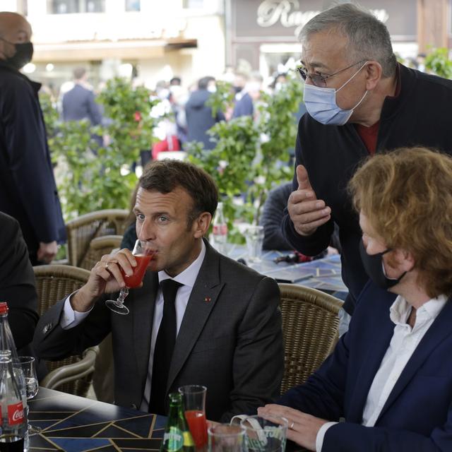 Le président français Emmanuel Macron partage un verre avec des commerçant.e.s à Nevers, le 21 mai 2021. [Keystone/epa - Thibault Camus/Pool Maxppp out]