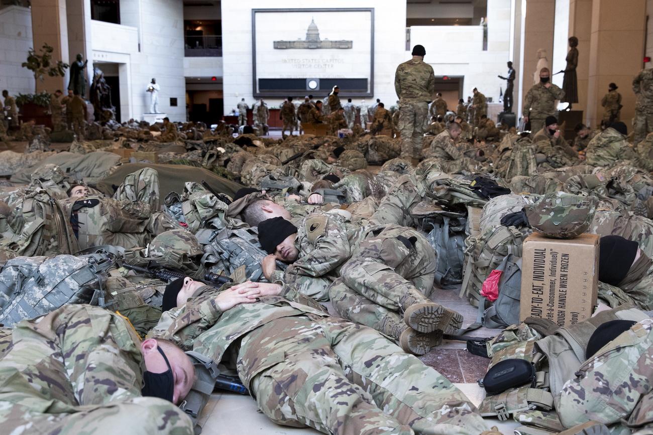 Des centaines de personnes des troupes de la Garde Nationale se reposent dans le centre des visites du Capitole. Capitol Hill, Washington DC, le 13 janvier 2021. [Keystone/epa - Michael Reynolds]