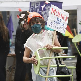 Des personnes sonnent l'"alarme climatique" à l'occasion de la Grève pour l'avenir, le 21 mai 2021 à Lausanne. [Keystone - Cyril Zingaro]
