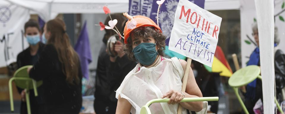 Des personnes sonnent l'"alarme climatique" à l'occasion de la Grève pour l'avenir, le 21 mai 2021 à Lausanne. [Keystone - Cyril Zingaro]