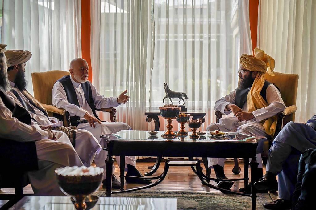 Une délégation talibane, menée par Anas Haqqani (à droite), rencontre d'anciens officiels travaillant pour le gouvernement afghan, dont l'ancien président Hamid Karzai (au centre gauche). Quelque part en Afghanistan, le 18 août 2021. [AFP - Compte Twitter de l'"Emirat Islamique d'Afghanistan"]