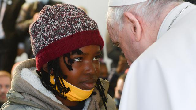 Dimanche 5 décembre: échange de regard intense entre une jeune fille du camp de migrants de Lesbos et le pape François, en visite sur l'île grecque. [AFP - Vatican Media]