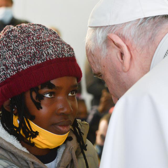 Dimanche 5 décembre: échange de regard intense entre une jeune fille du camp de migrants de Lesbos et le pape François, en visite sur l'île grecque. [AFP - Vatican Media]