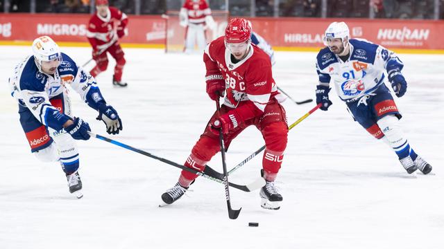 Lukas Frick prend le meilleur sur les Zurichois Denis Hollenstein et John Quenneville. [Pascal Muller]