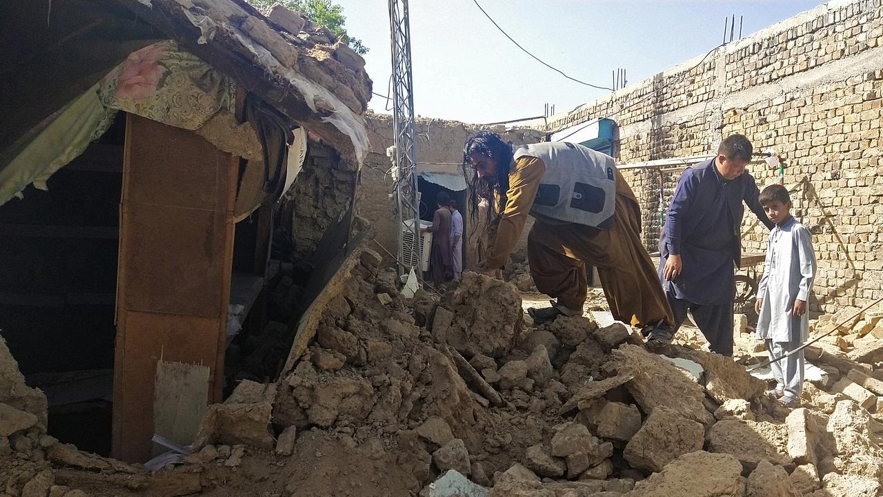 Des habitants au milieu des décombres d'une maison détruite dans le district de Harnai au sud du Pakistan, le 7 octobre 2021. [AFP - Banaras Khan]