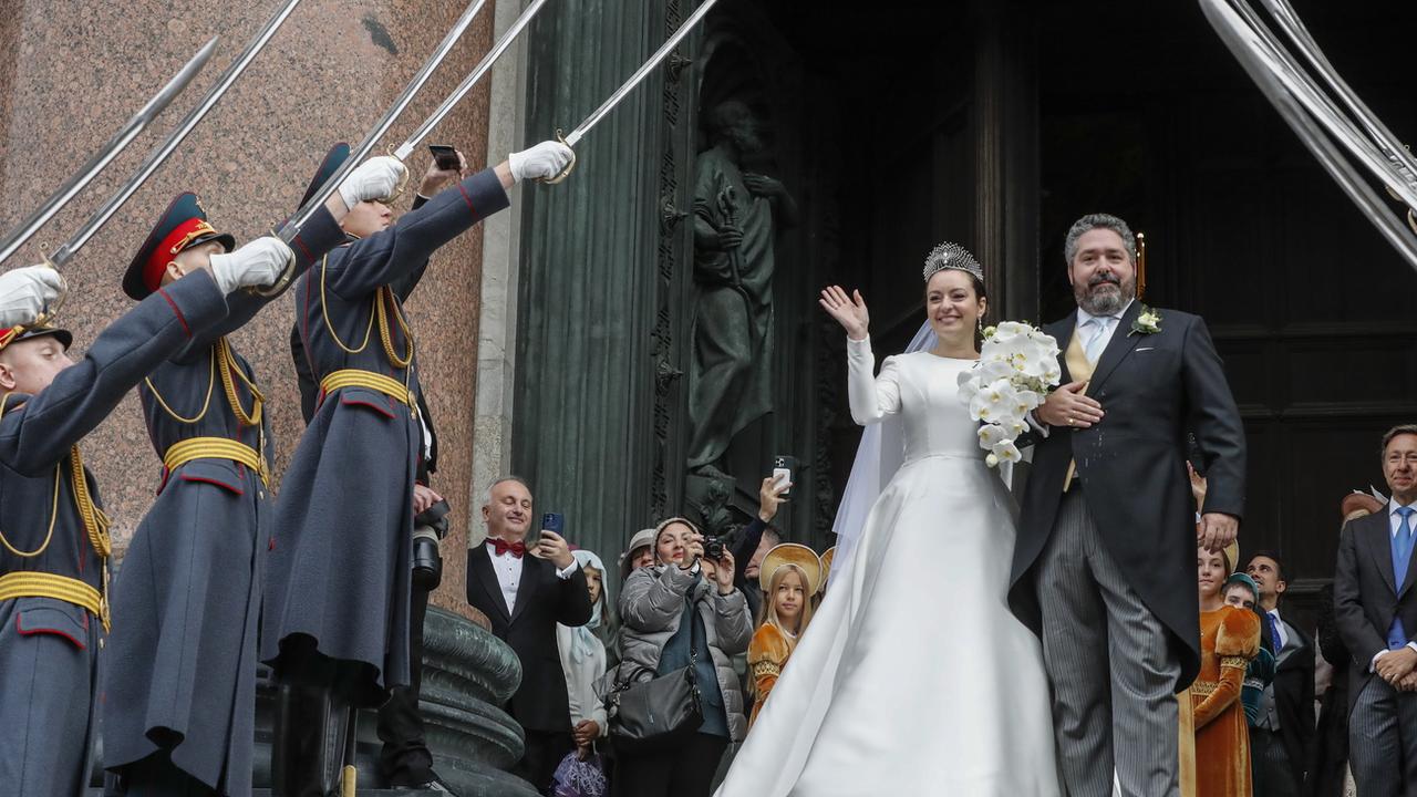 Le grand-duc Gueorgui Romanov et son épouse Rebecca Bettarini à la sortie de leur cérémonie de mariage à la cathédrale Saint-Isaac. [KEYSTONE - Anatoly Maltsev / EPA]