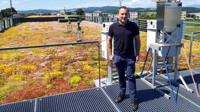 Benoit Crouzy sur le toit du centre technique de météosuisse, à Payerne. [RTS - Bastien von Wyss]