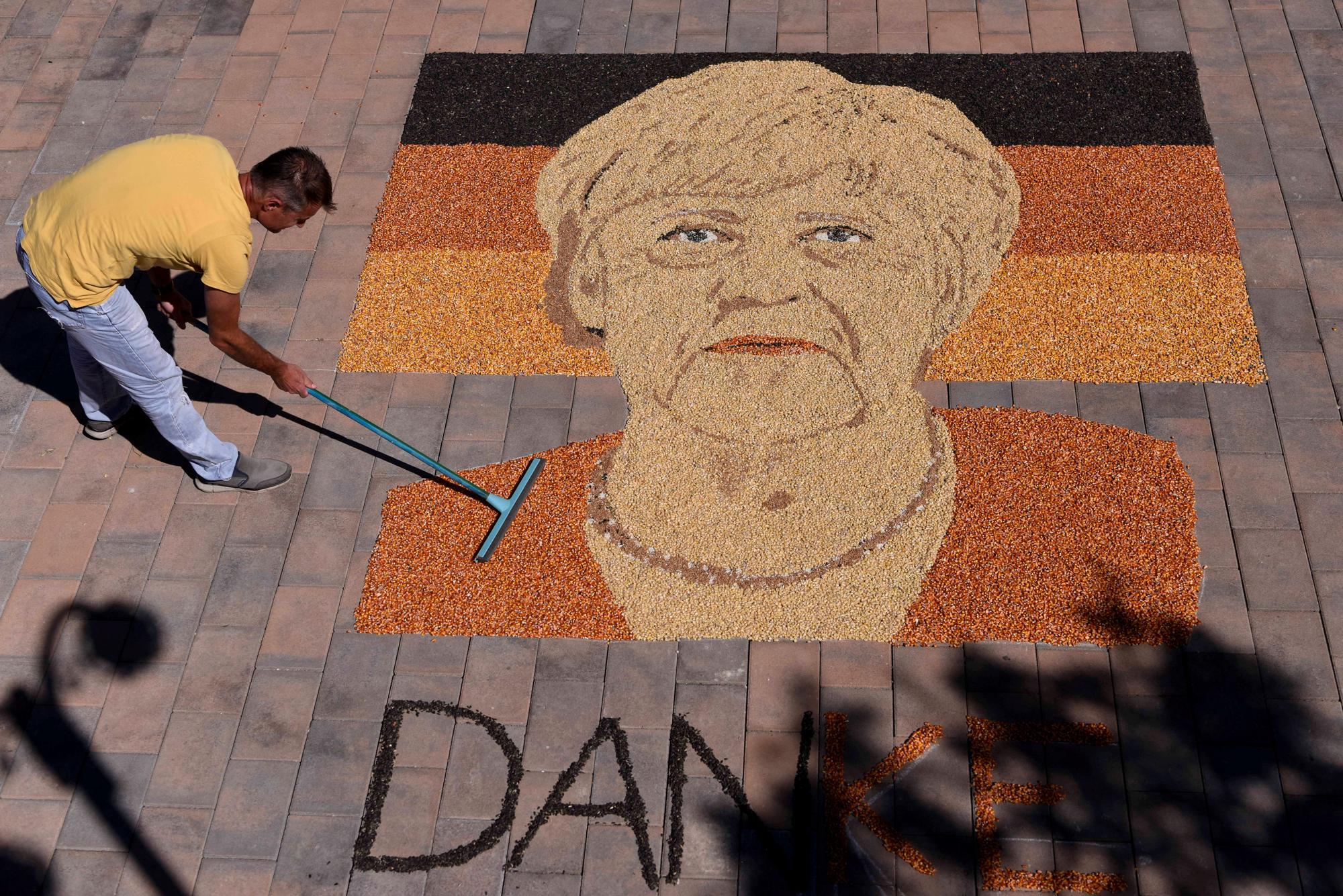 L'artiste kosovare Alkent Pozhegu finalise son portrait d'Angela Merkel en grains de maïs et graines, avec le mot "merci" (danke). [ASFP - ARMEND NIMANI]