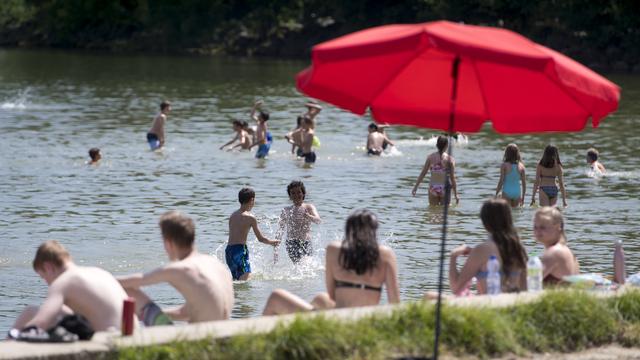 Des enfants jouent dans le lac de Neuchâtel à Yverdon-les-Bains. [KEYSTONE - Laurent Gillieron]